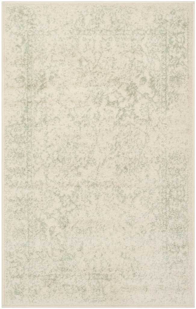 A compact ivory accent rug features barely-there sage botanical detailing.