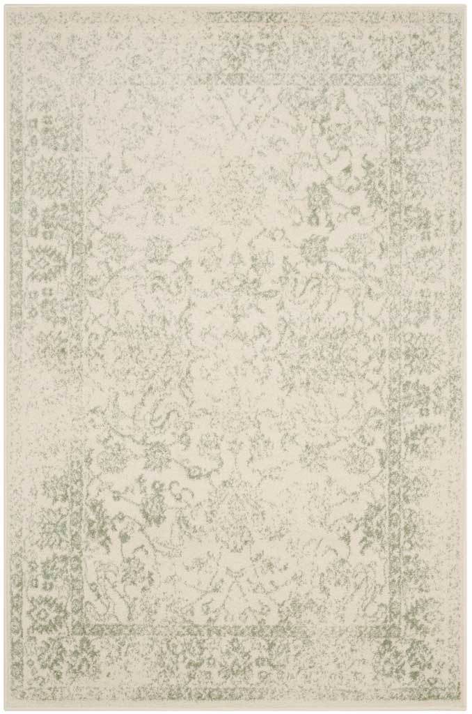 An ivory field carries faded sage florals within a subtle ornamental frame.