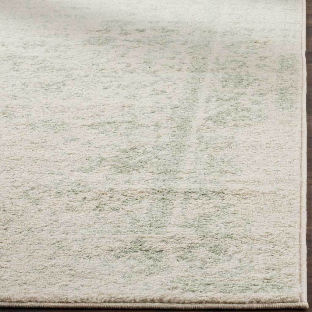 Soft ivory pile is flecked with sage above a neatly bound edge.