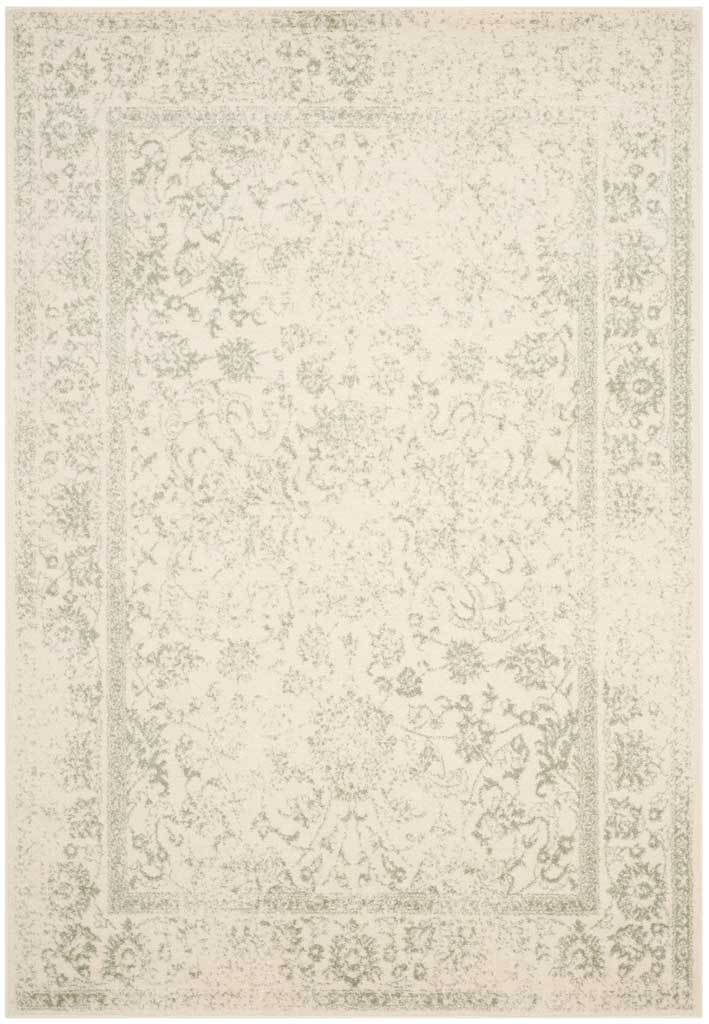 Muted sage scrolls surround a softly faded ivory field on this rectangular rug.