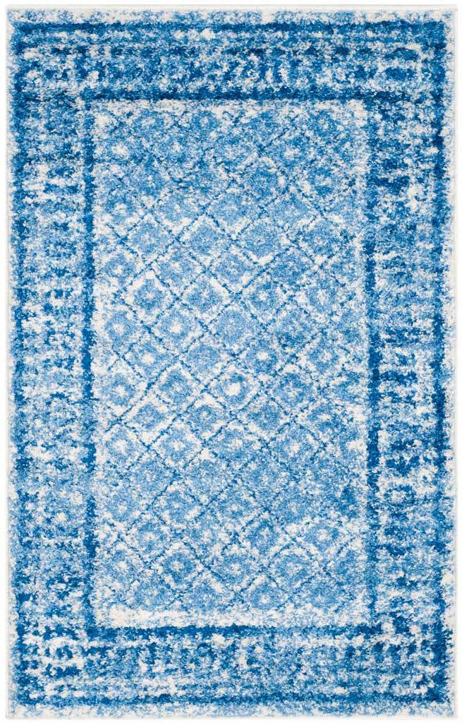 Compact blue and silver rug features softly faded diamonds and a richly textured border