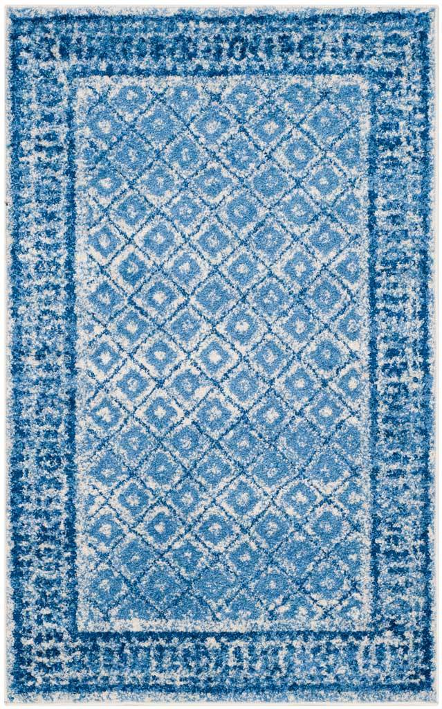 Weathered blue latticework and a decorative border bring vintage character to a compact rug