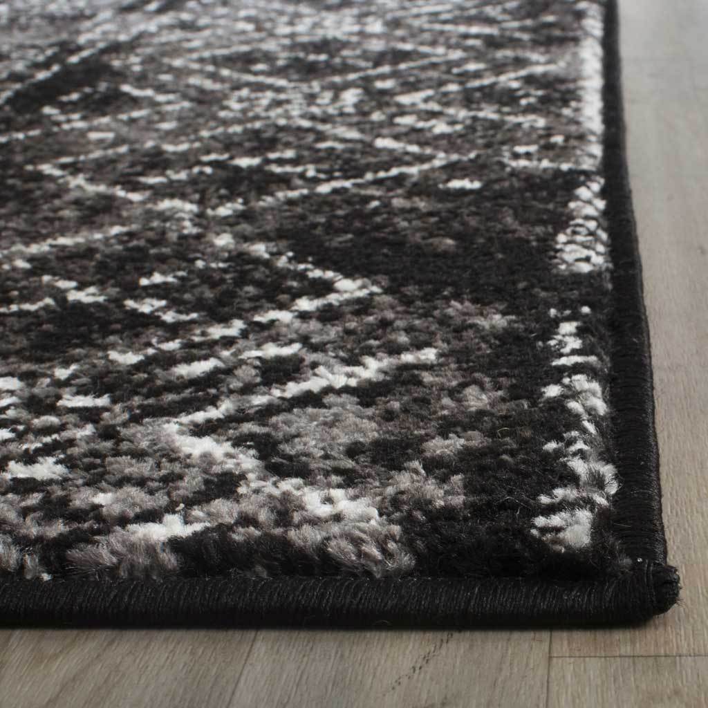 Black bound edges frame a textured pile flecked with silver geometric accents.