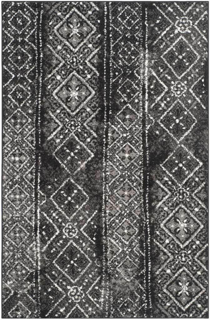 Rectangular black rug features silvery diamond motifs in a softly weathered design