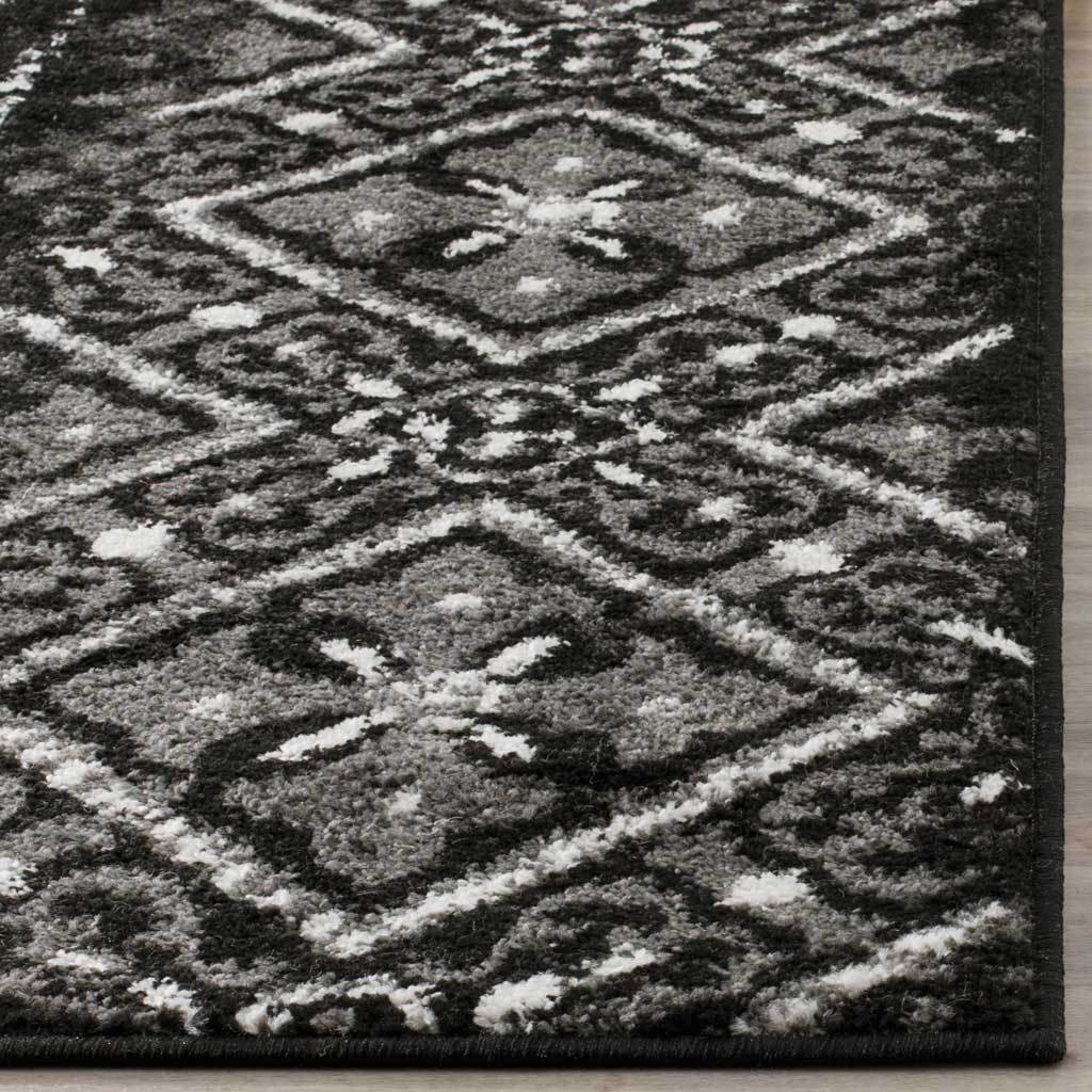 Silvery floral diamonds pop against textured black pile with neatly bound edges