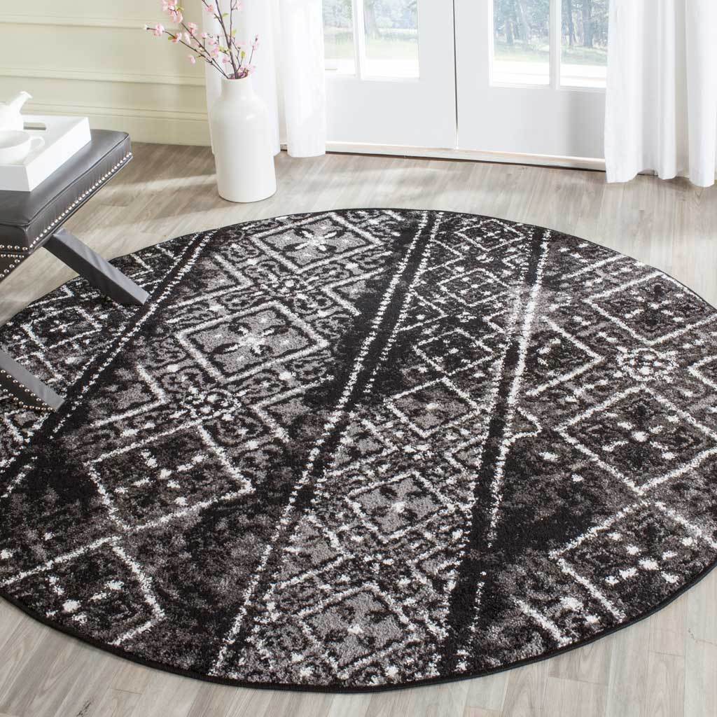 Layered black and silver patterns give this round rug vintage-inspired character.