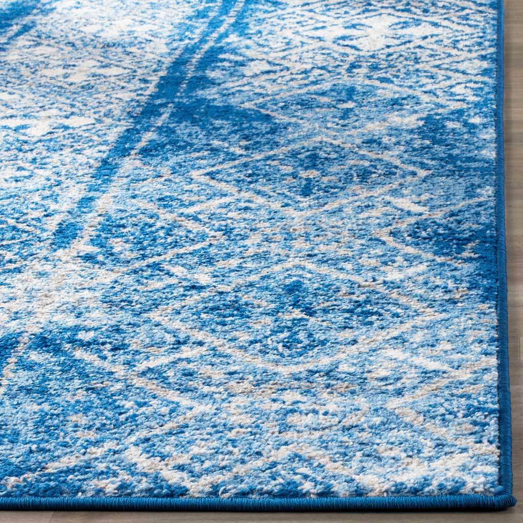 Soft blue and silver motifs meet a neatly bound blue edge on the textured pile