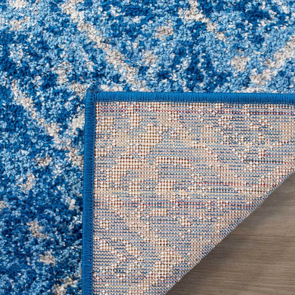 Woven underside and bright blue binding complement the rug's patterned pile
