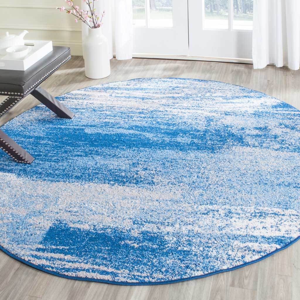 Cool blue and silver streaks give this round rug a flowing, modern look