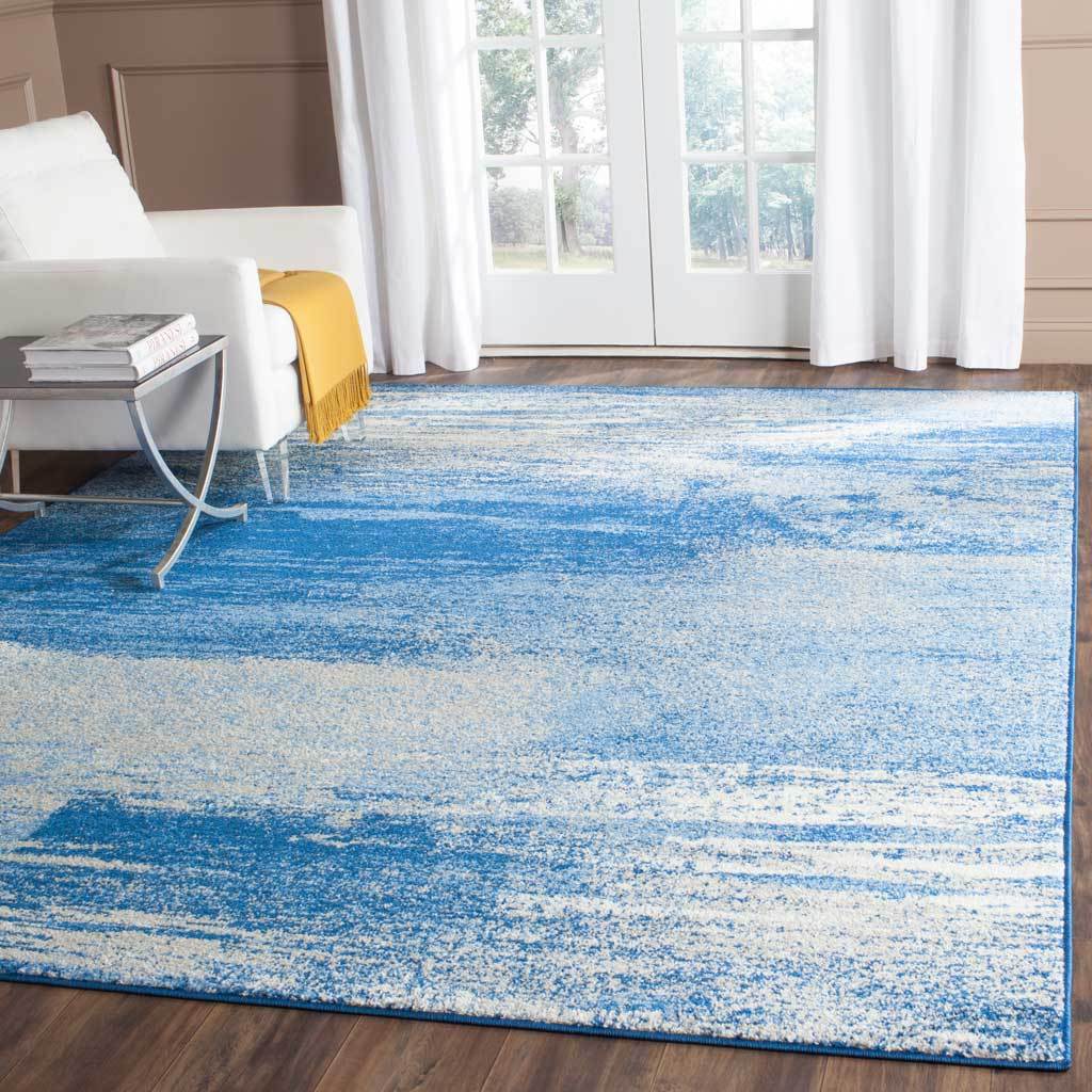 Silver and blue abstract rug brings cool, sweeping color to a bright living space