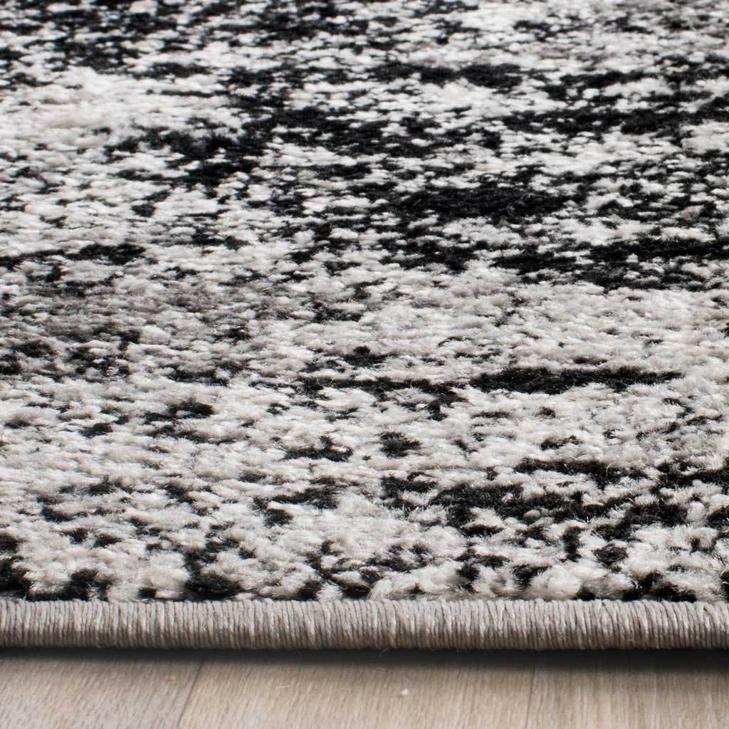 Charcoal and pale silver fibers meet a neatly bound edge for a tailored finish