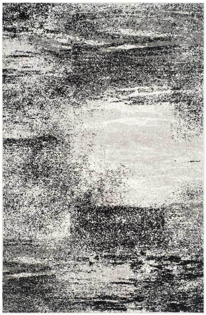 Silver and black abstract rug with a light center and densely speckled dark edges