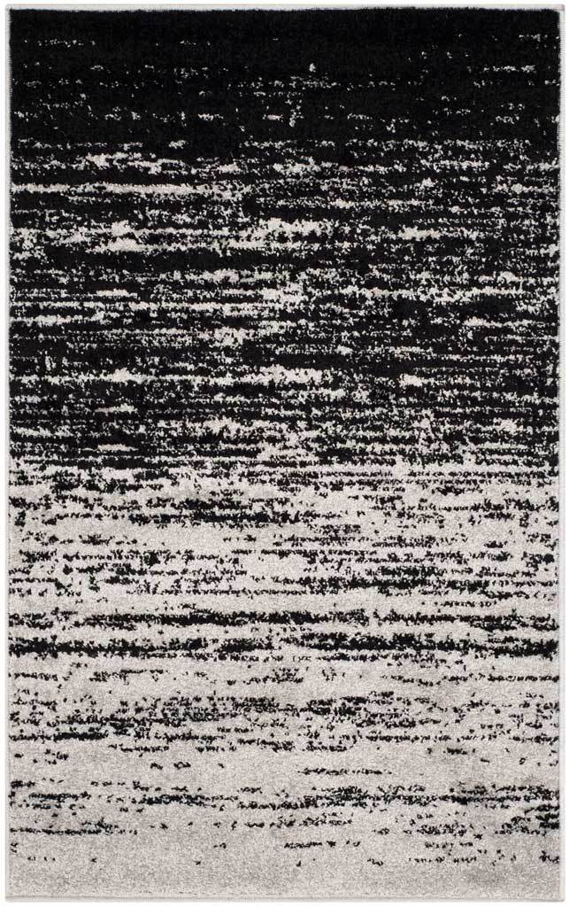Black bands dissolve into silver for bold contrast on this compact accent rug.