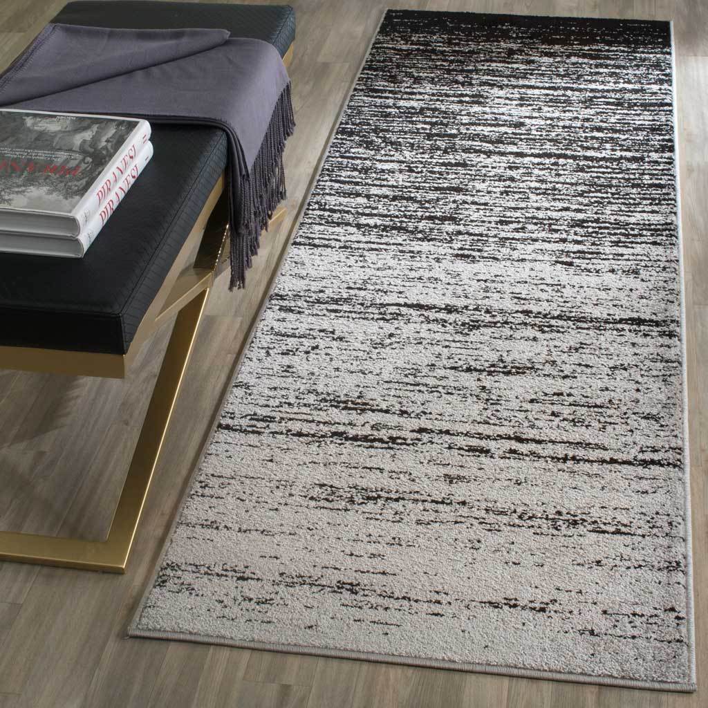 Bold black-to-silver shading and weathered streaks give this runner graphic contrast