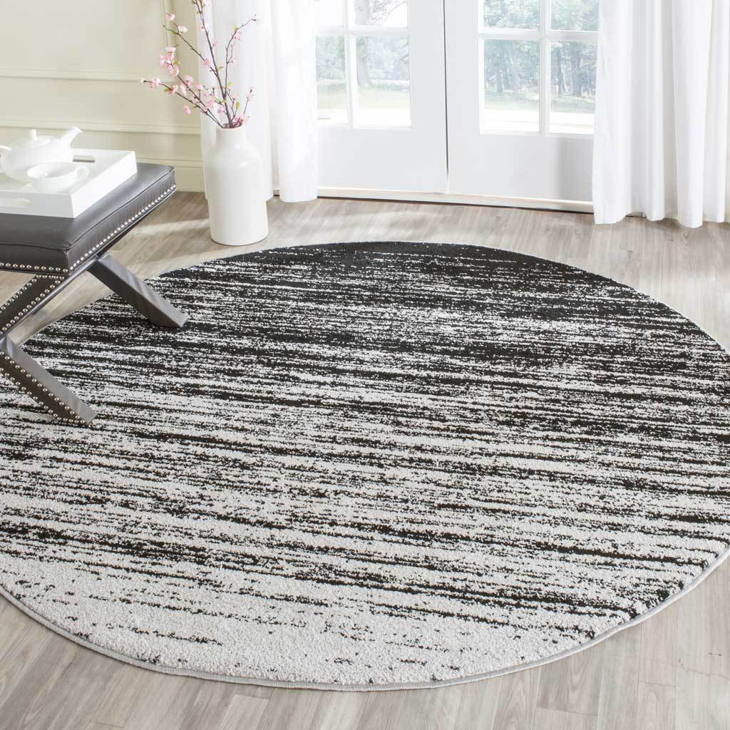 Contrasting black and silver striations bring graphic texture to this round rug