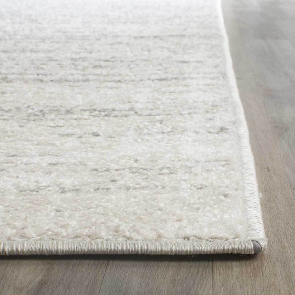 Soft ivory pile and neatly bound edges frame the runner's subtle silver flecks