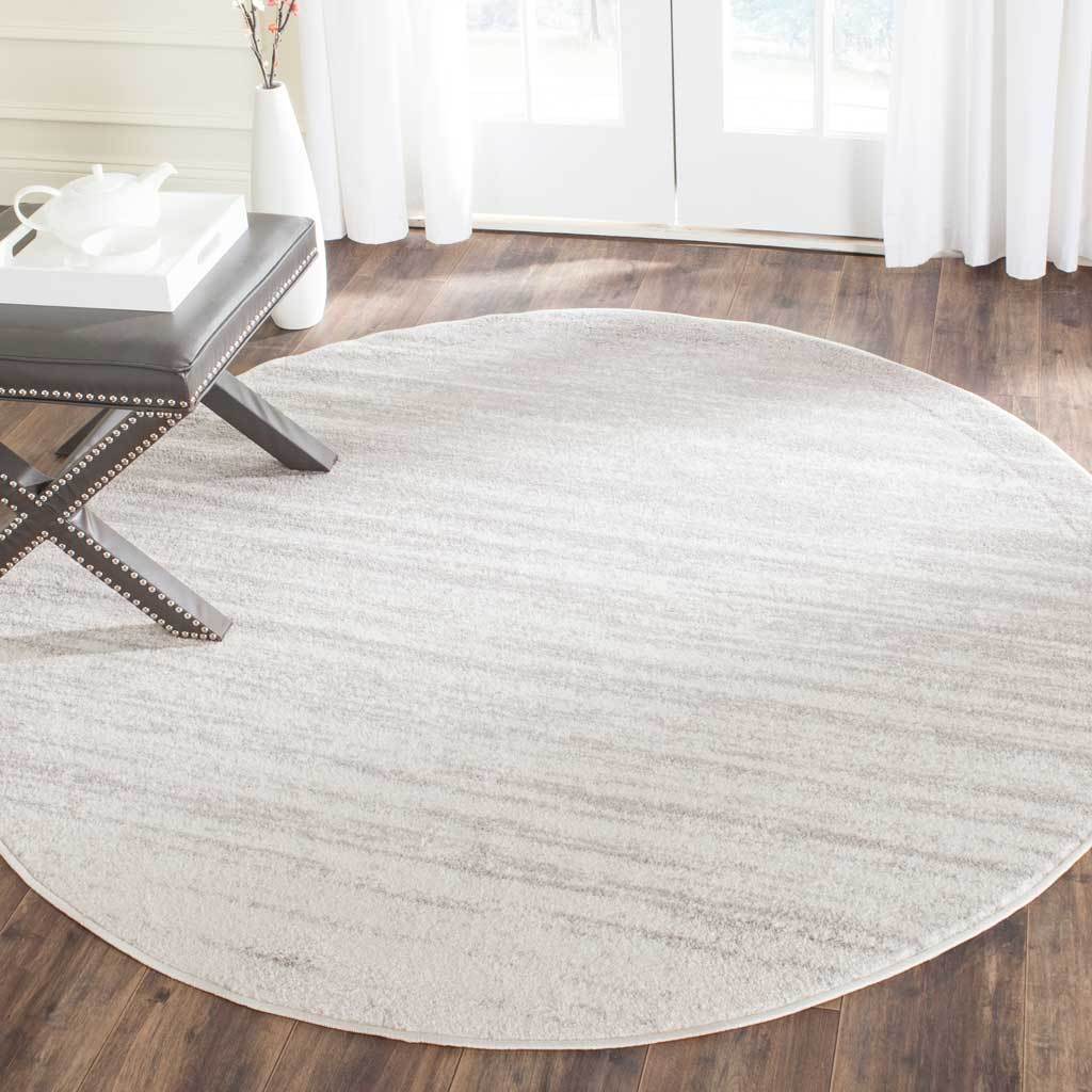 A gentle ivory-to-silver gradient adds quiet texture to this round rug
