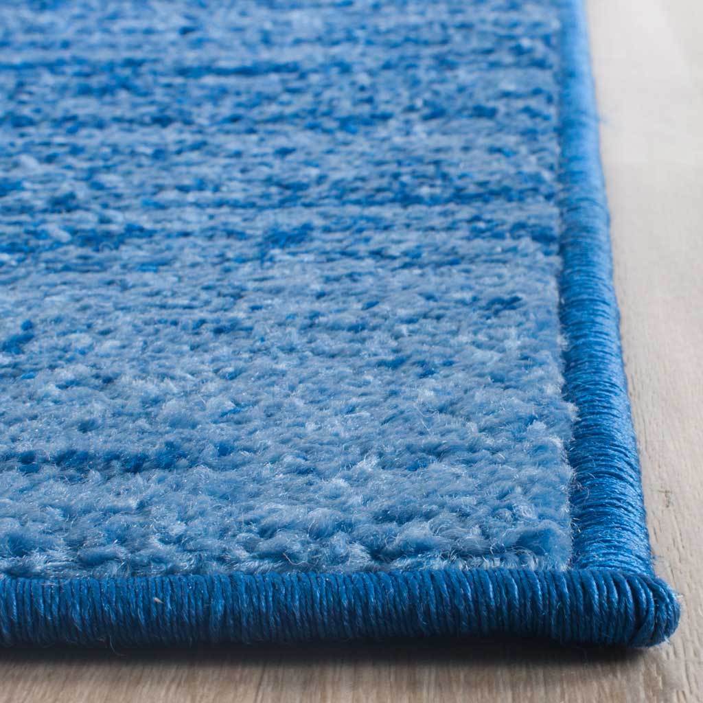 Blue textured pile meets a neatly wrapped edge for a crisp, finished border