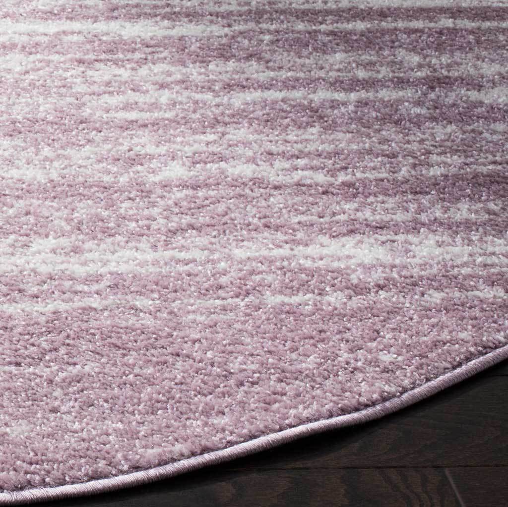 Cream flecks brighten muted purple pile beside a neatly finished edge