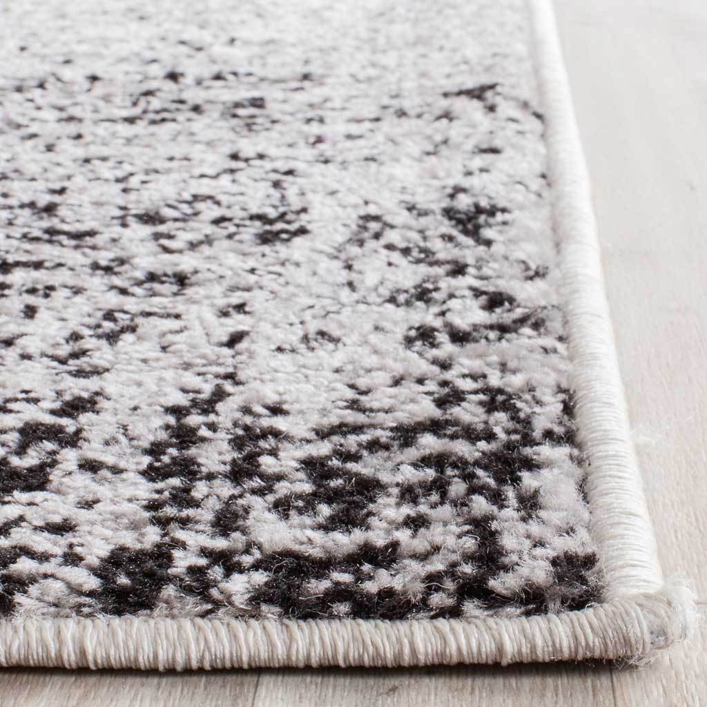 Silver and black speckles extend to a neatly bound rug corner