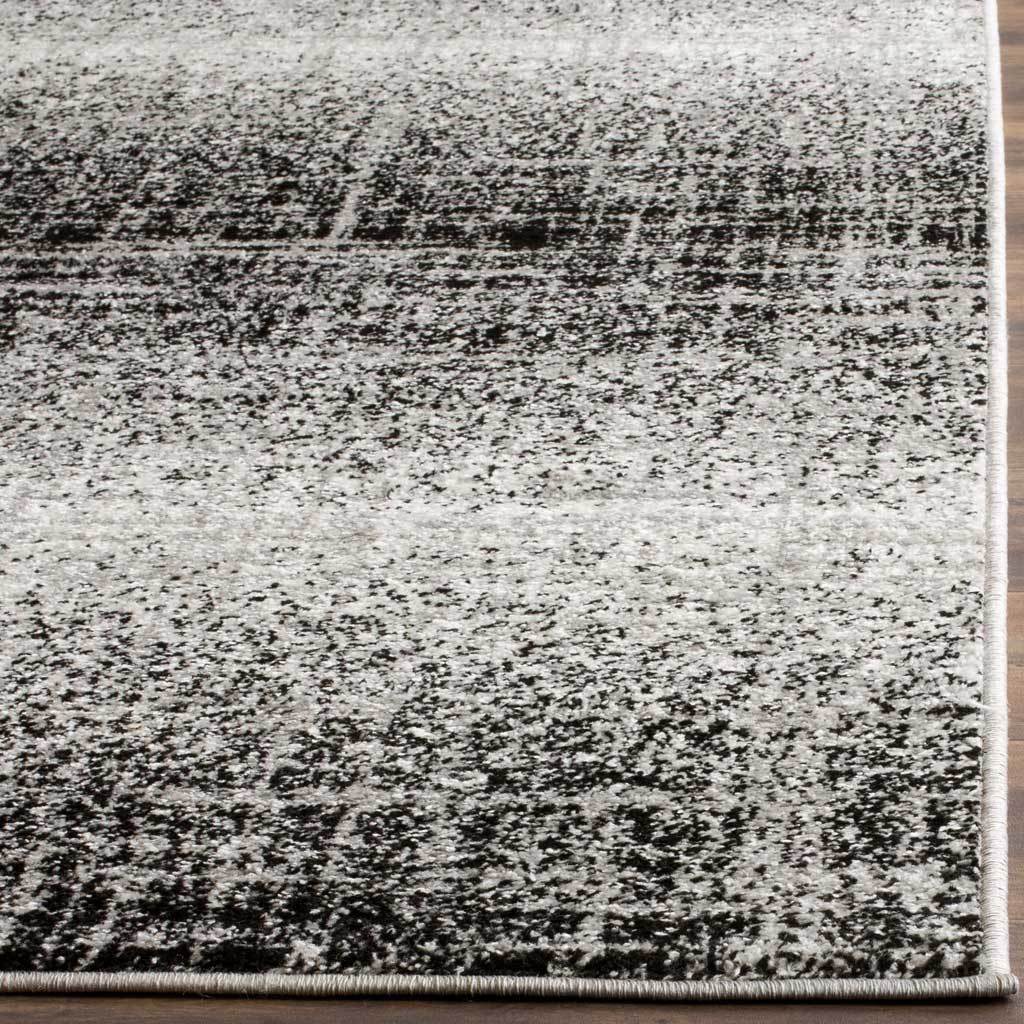 Short silver and black pile has broken dark lines and a neatly bound edge