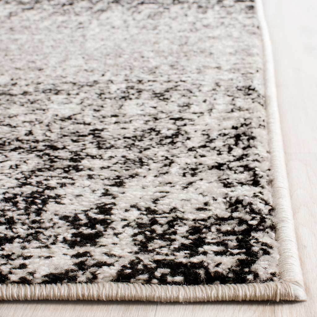 Ivory and black flecked fibers meet a neatly bound corner for a finished edge
