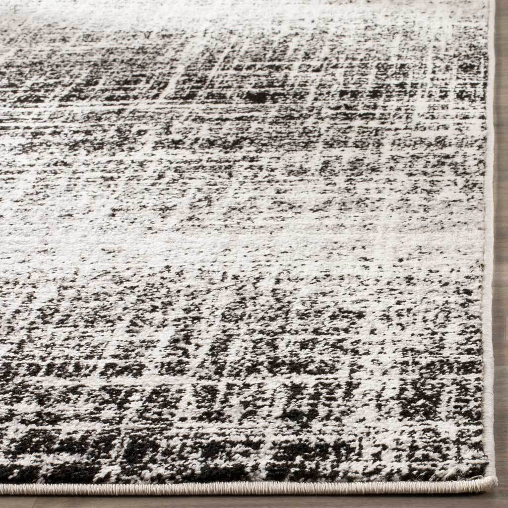 Ivory and black broken-line pattern continues to the rug's neatly wrapped edges