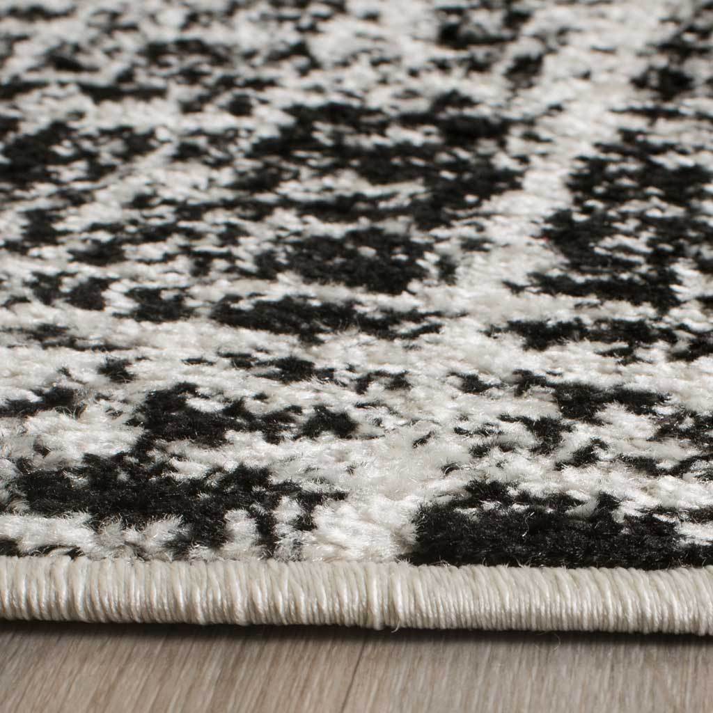 Textured ivory and black pile meets a tightly bound edge