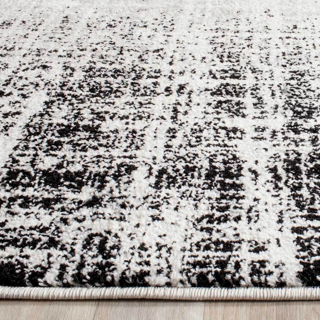 Dense ivory pile is flecked with black and finished with a neatly wrapped edge