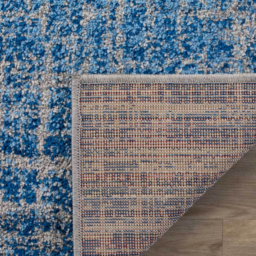 Woven jute backing and neat binding complement the rug's blue and silver textured pile