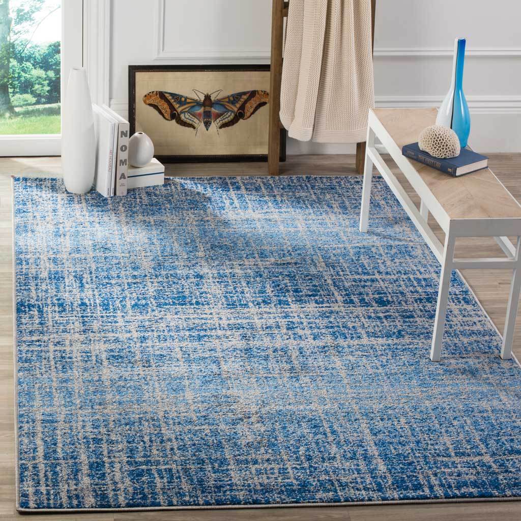 Blue and silver rug adds layered crosshatching and faded blue bands beneath a modern bench