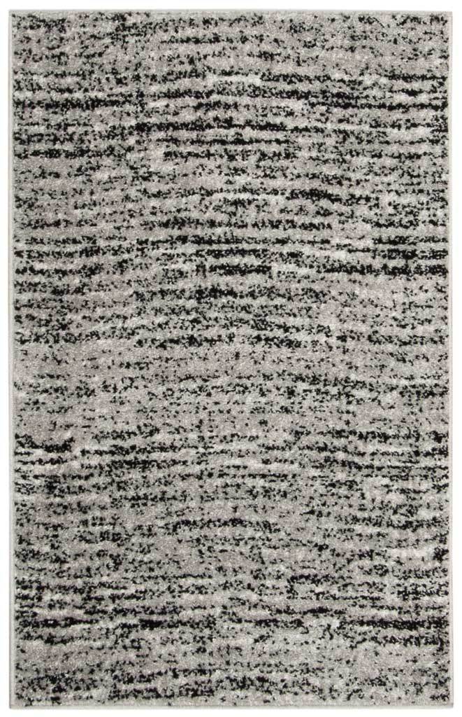 Compact black and silver accent rug with bold, uneven lines and a softly mottled ground
