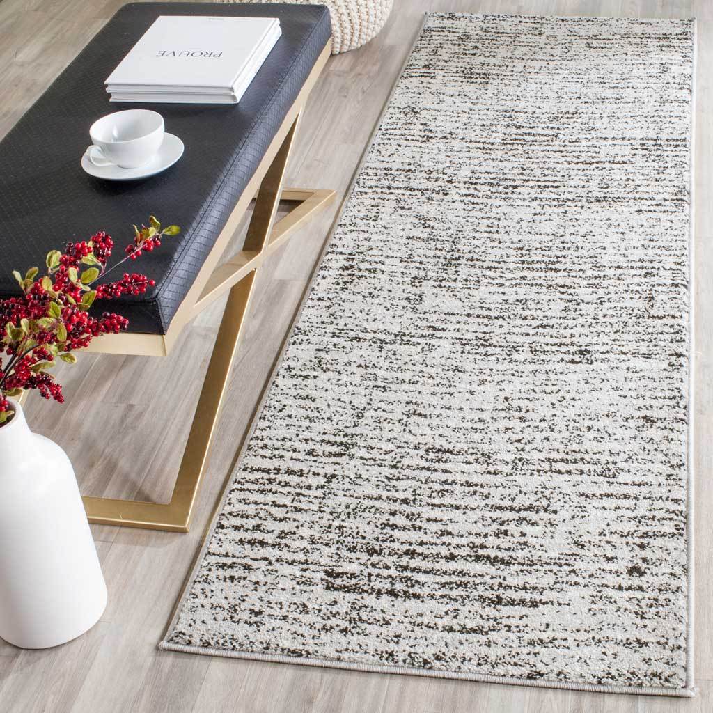 A black and silver runner adds an abstract pattern to a long, narrow floor space