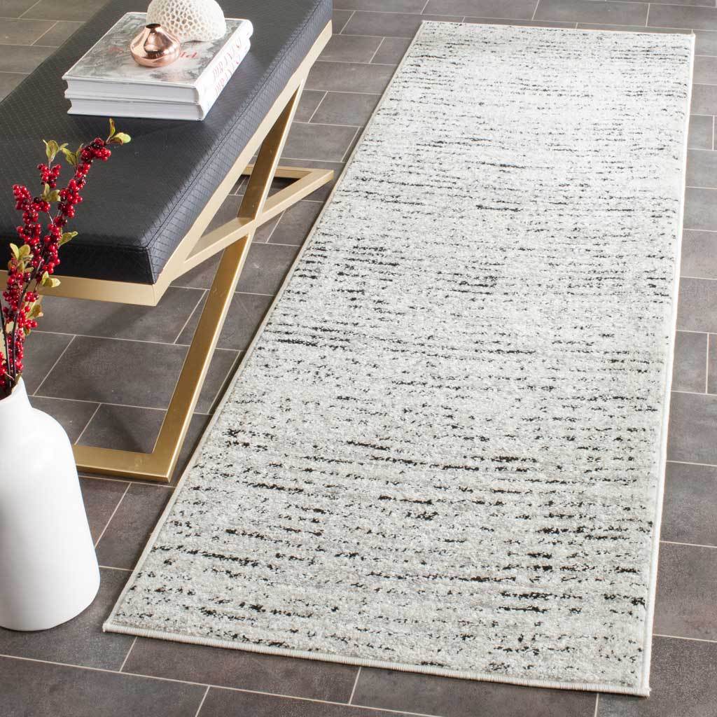 Ivory and silver runner with scattered dark striations brings subtle texture to the floor