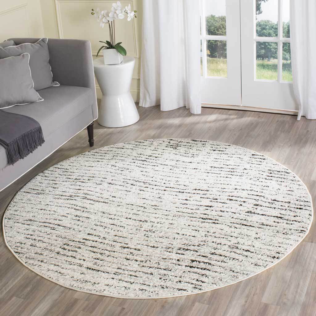Ivory round rug brightens the floor with fine, irregular streaks and gentle contrast