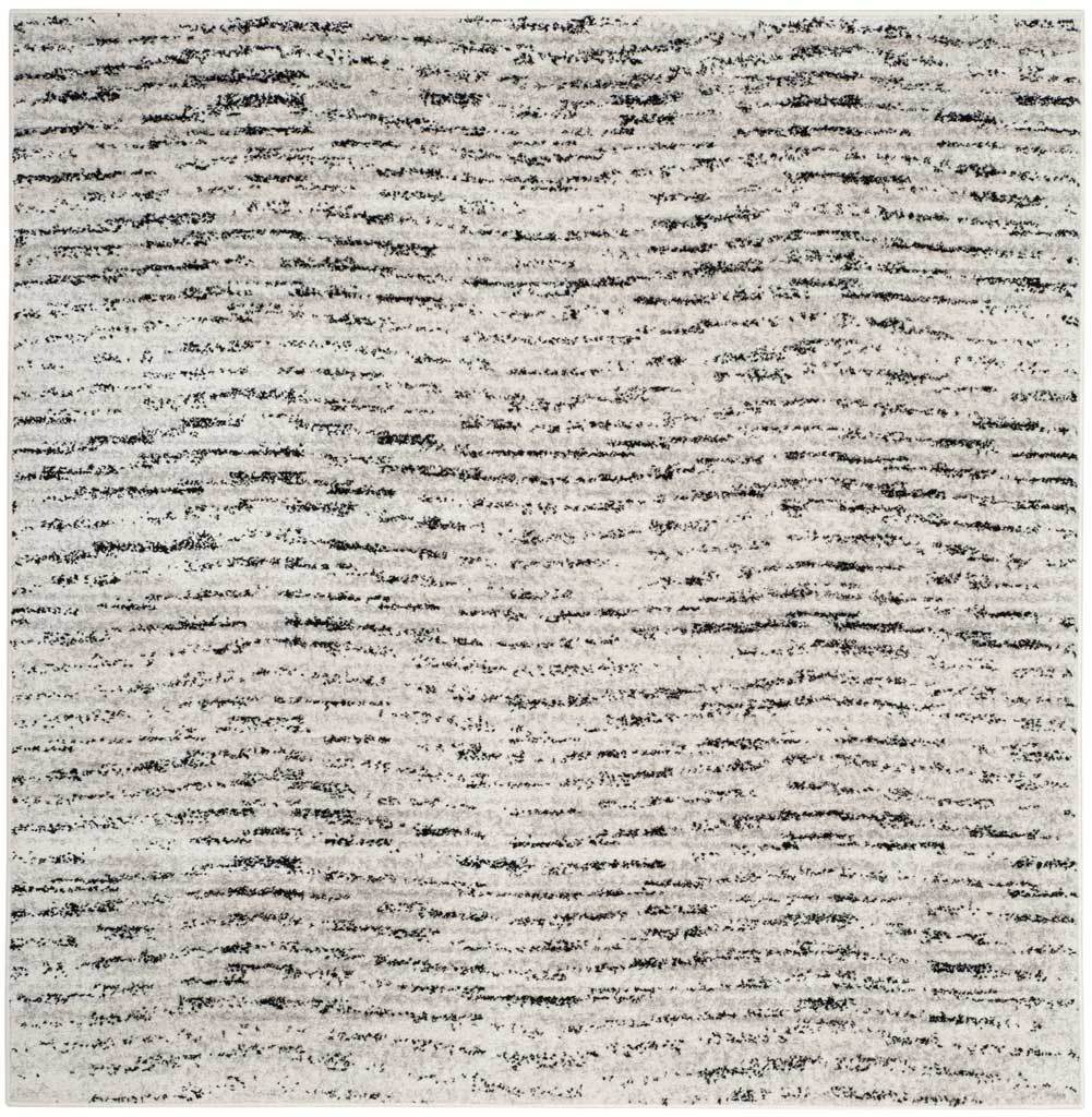 Square ivory and silver rug with broken dark lines and a light, textured ground