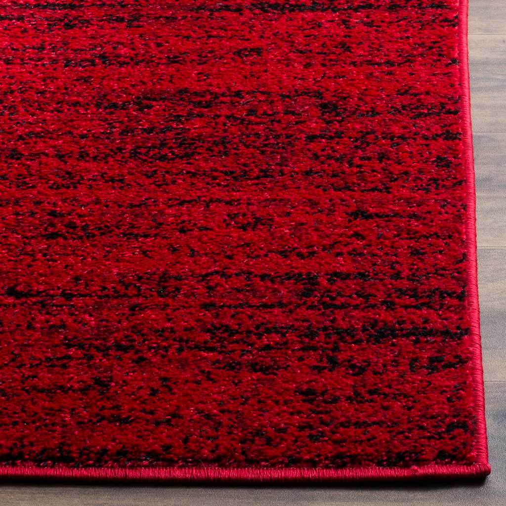 Crimson red and black striations meet a clean bound edge on this textured rug