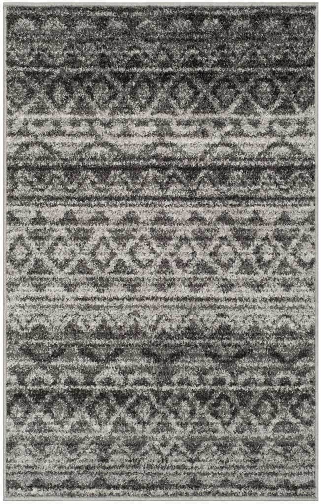 Dense charcoal motifs and ivory bands give this compact accent rug a richly layered look.