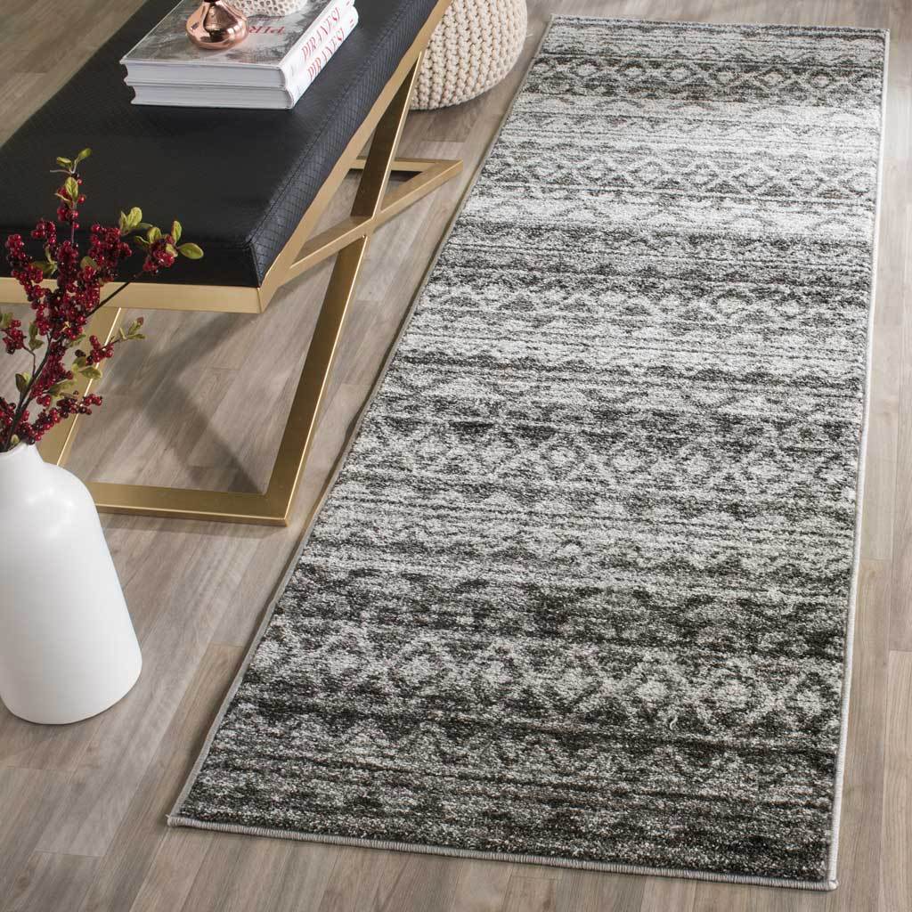 An ivory and charcoal runner adds geometric texture alongside a sleek bench