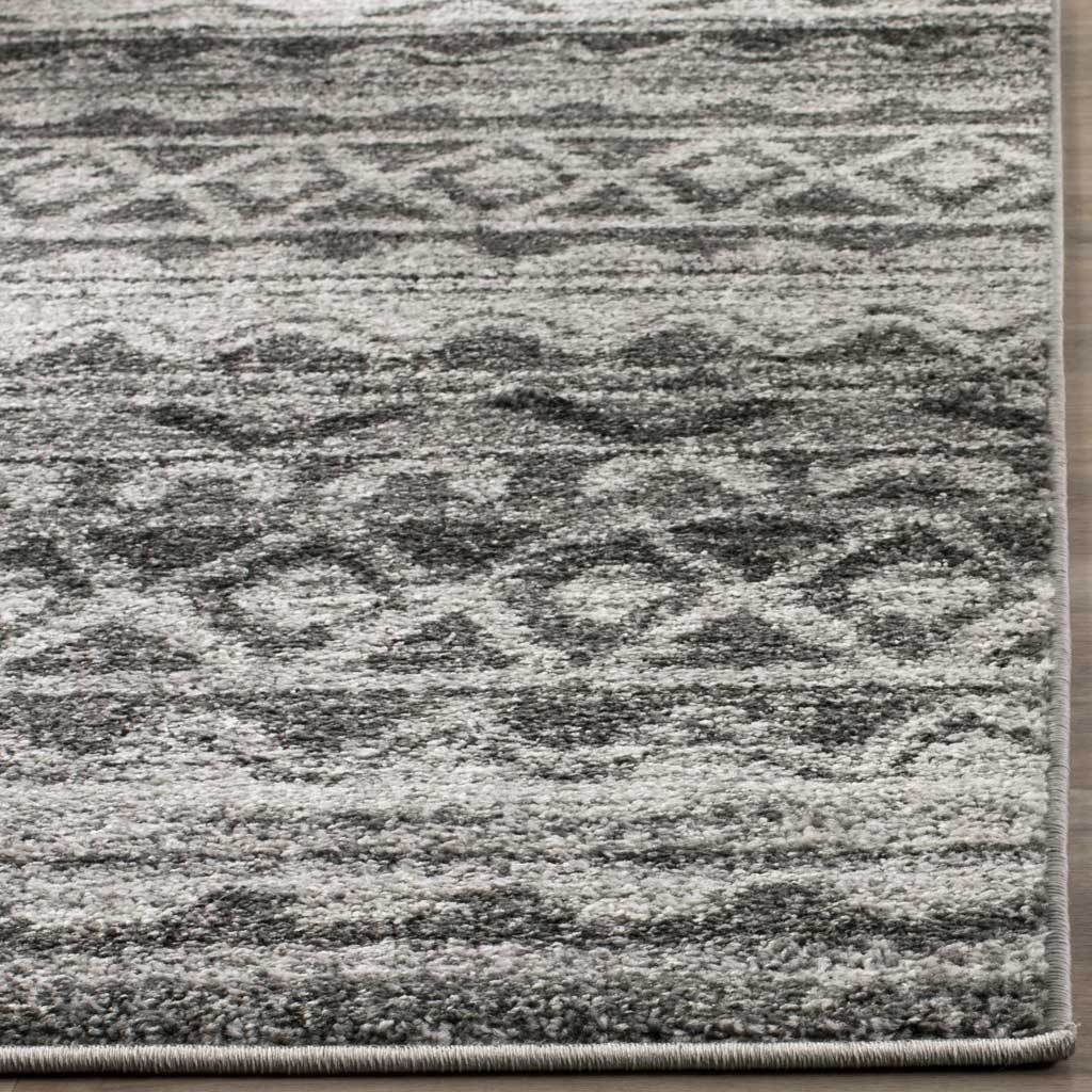 Soft charcoal swirls blend with ivory stripes, finished with neatly bound edges.