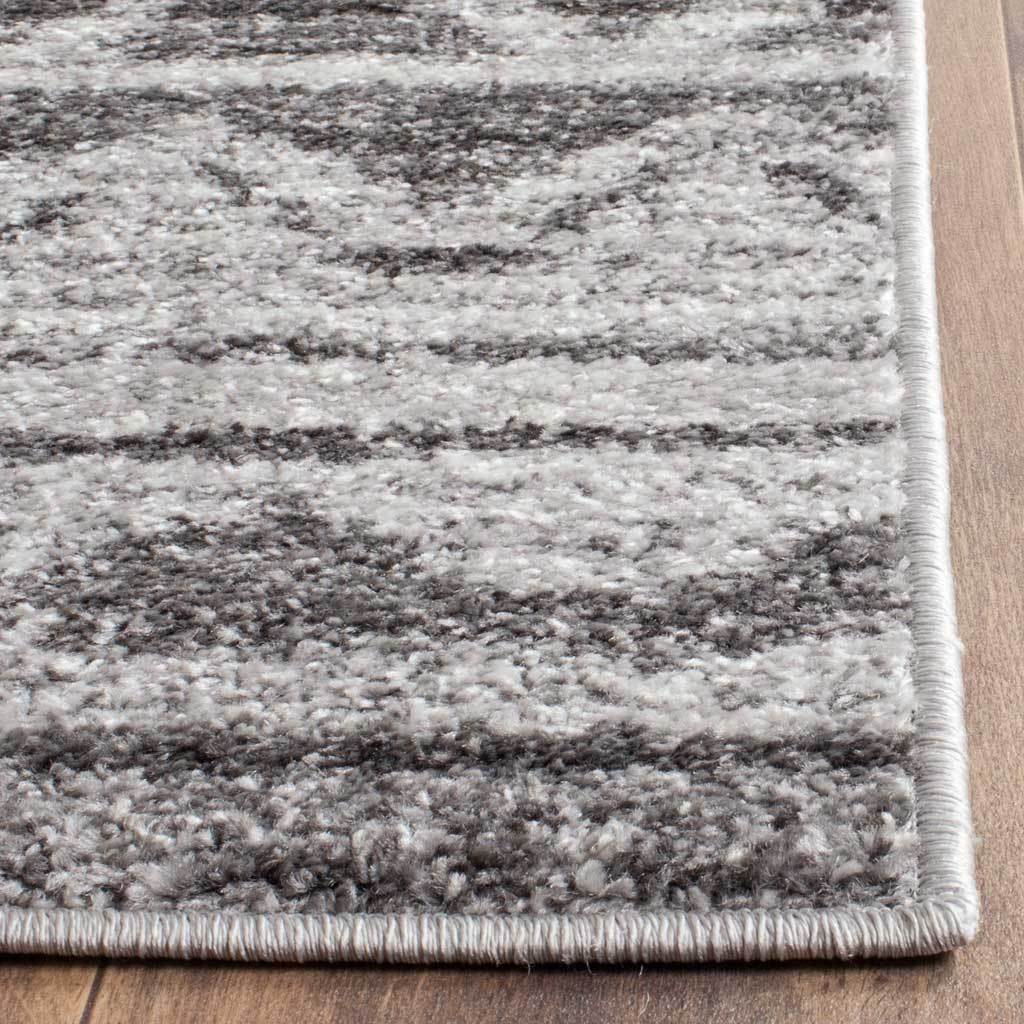 Textured ivory and charcoal fibers meet neatly bound edges for a polished finish.