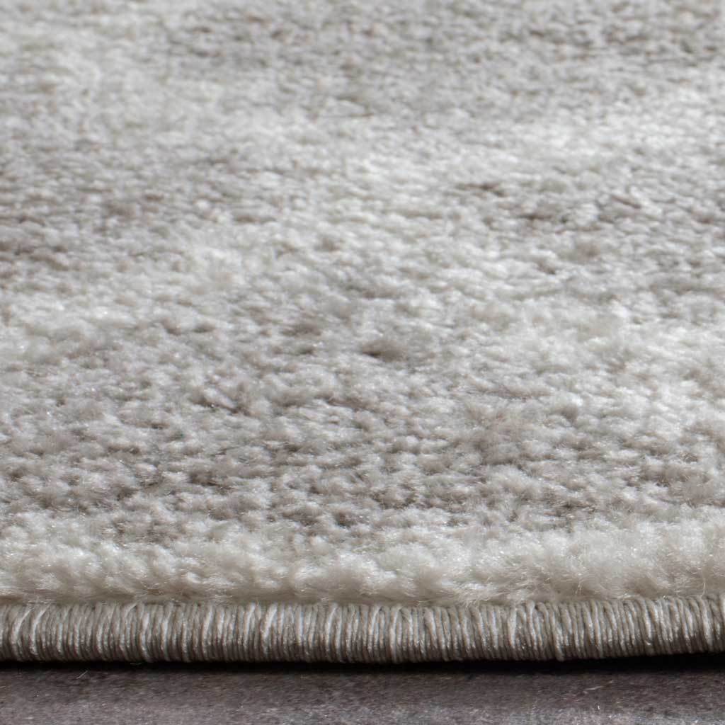 Textured silver and ivory pile meets a neatly bound edge on this runner rug.