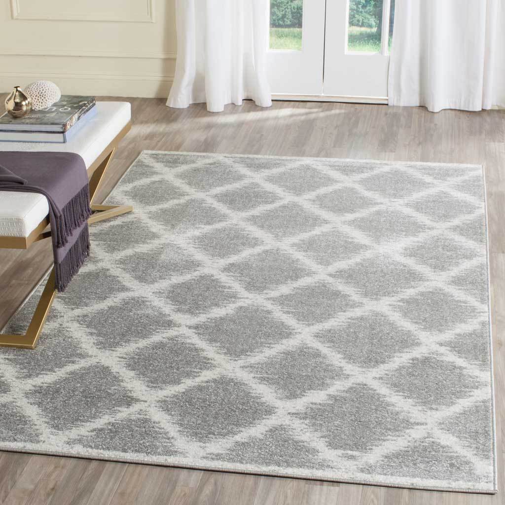 A silver and ivory diamond trellis rug adds soft geometric texture to a light-filled living space