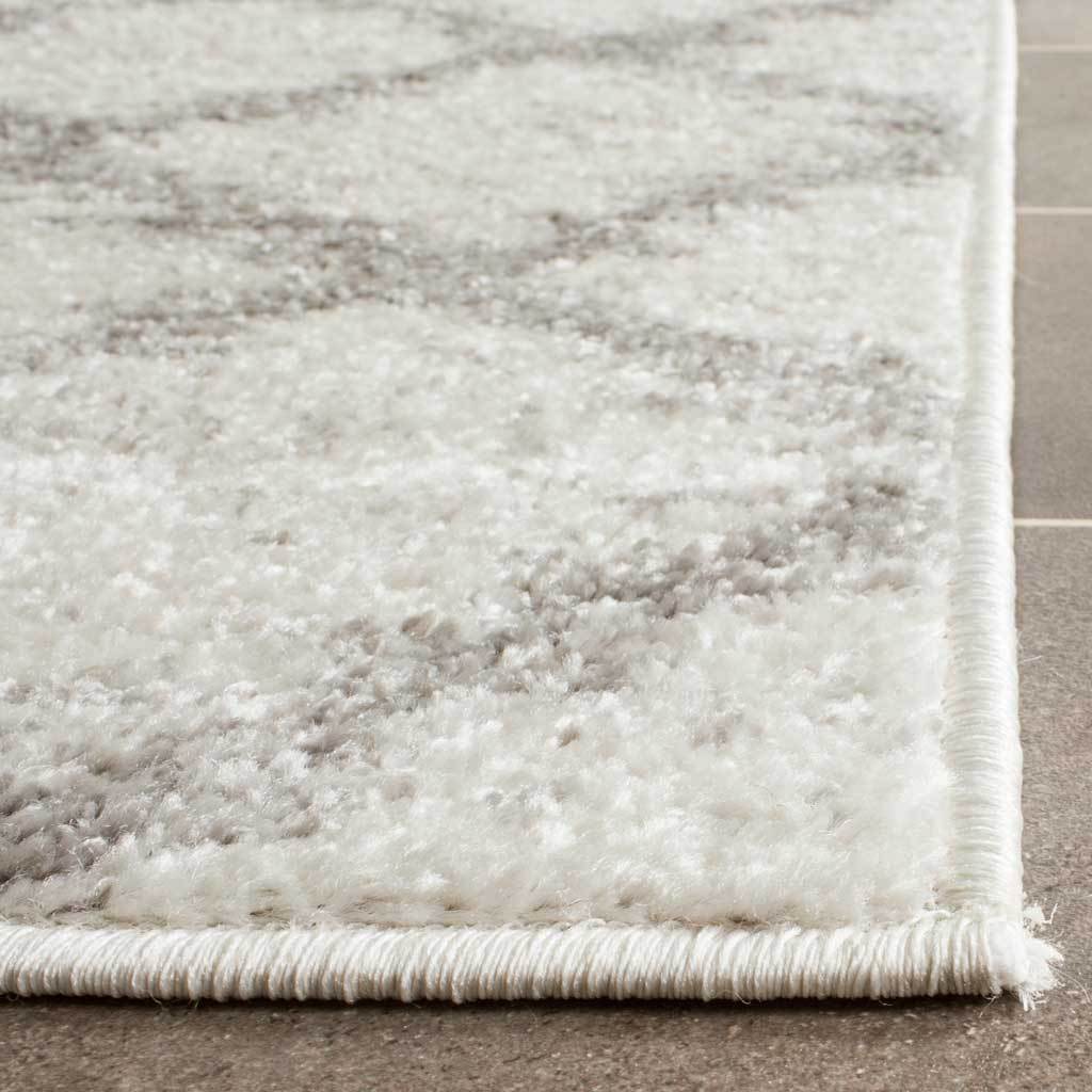 Soft ivory and silver pile meets neatly bound edges for a cozy, tailored runner rug.