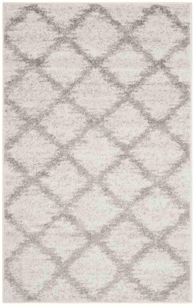 Silver diamond motifs accent the ivory ground of this compact rectangular rug