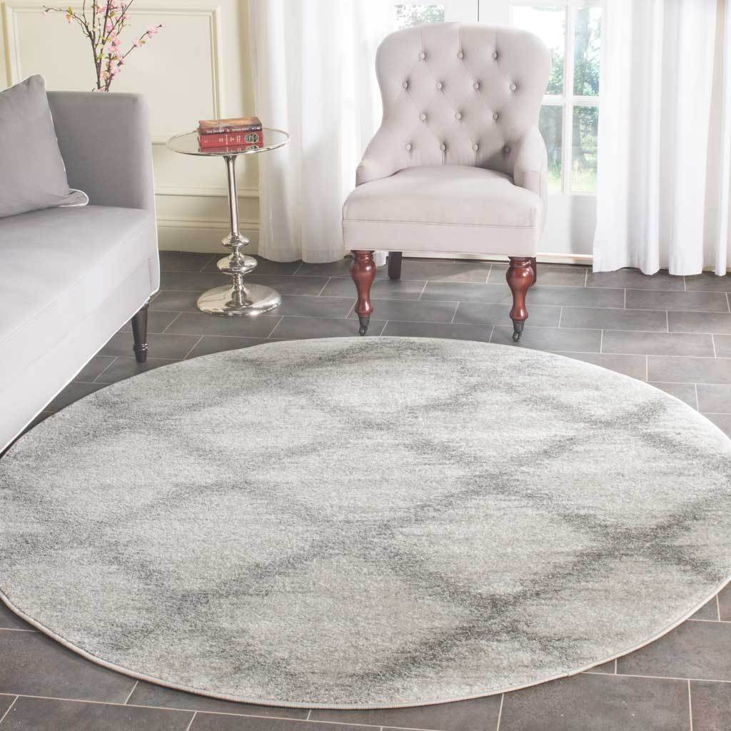 An ivory and silver round rug brings muted pattern and softness to the seating area