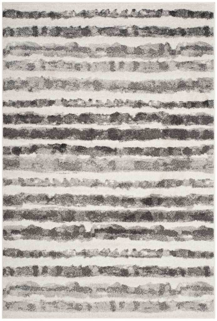Charcoal bands ripple across an ivory rug, creating an abstract stripe pattern