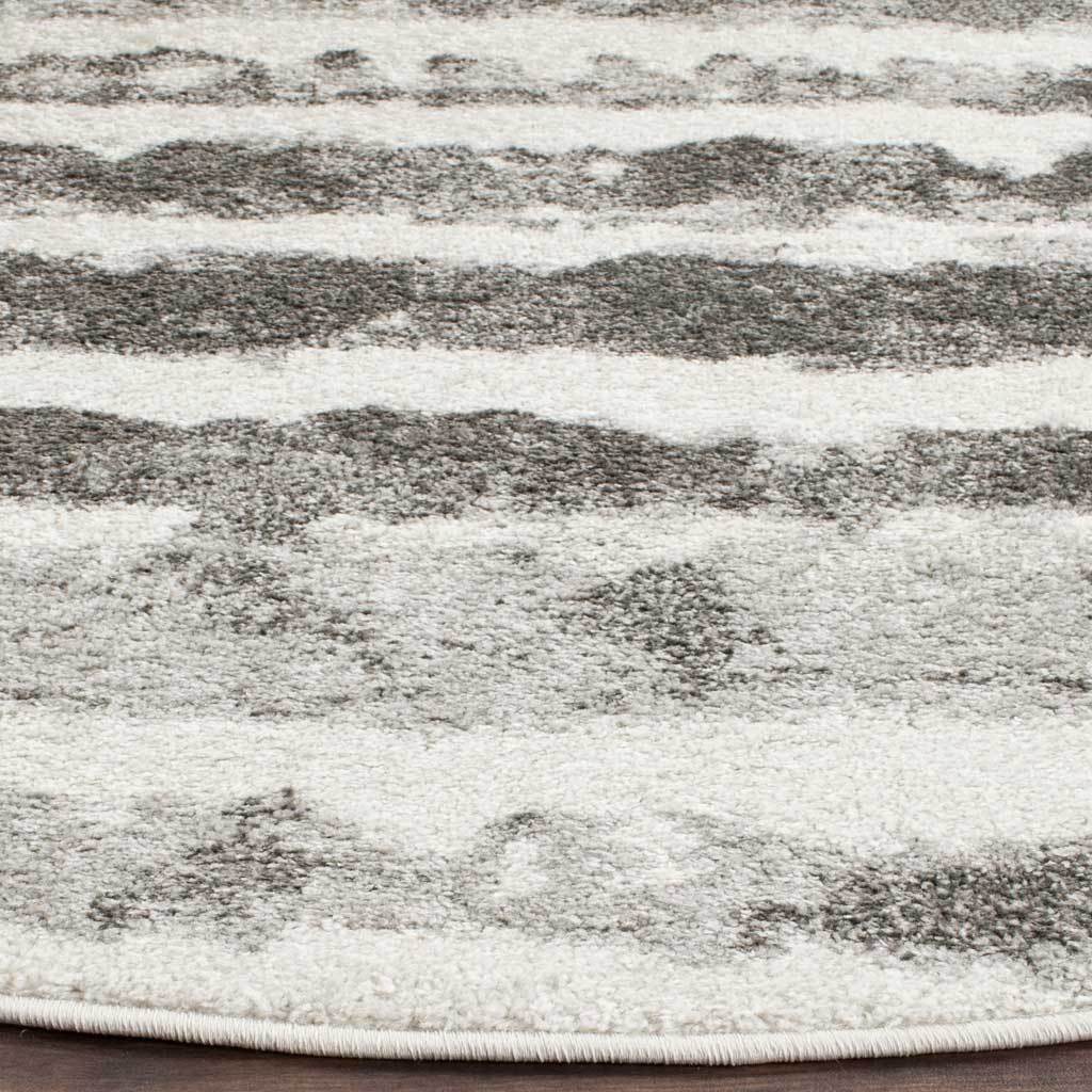Ivory and charcoal fibers create a soft, low-profile texture finished with a neatly bound edge.
