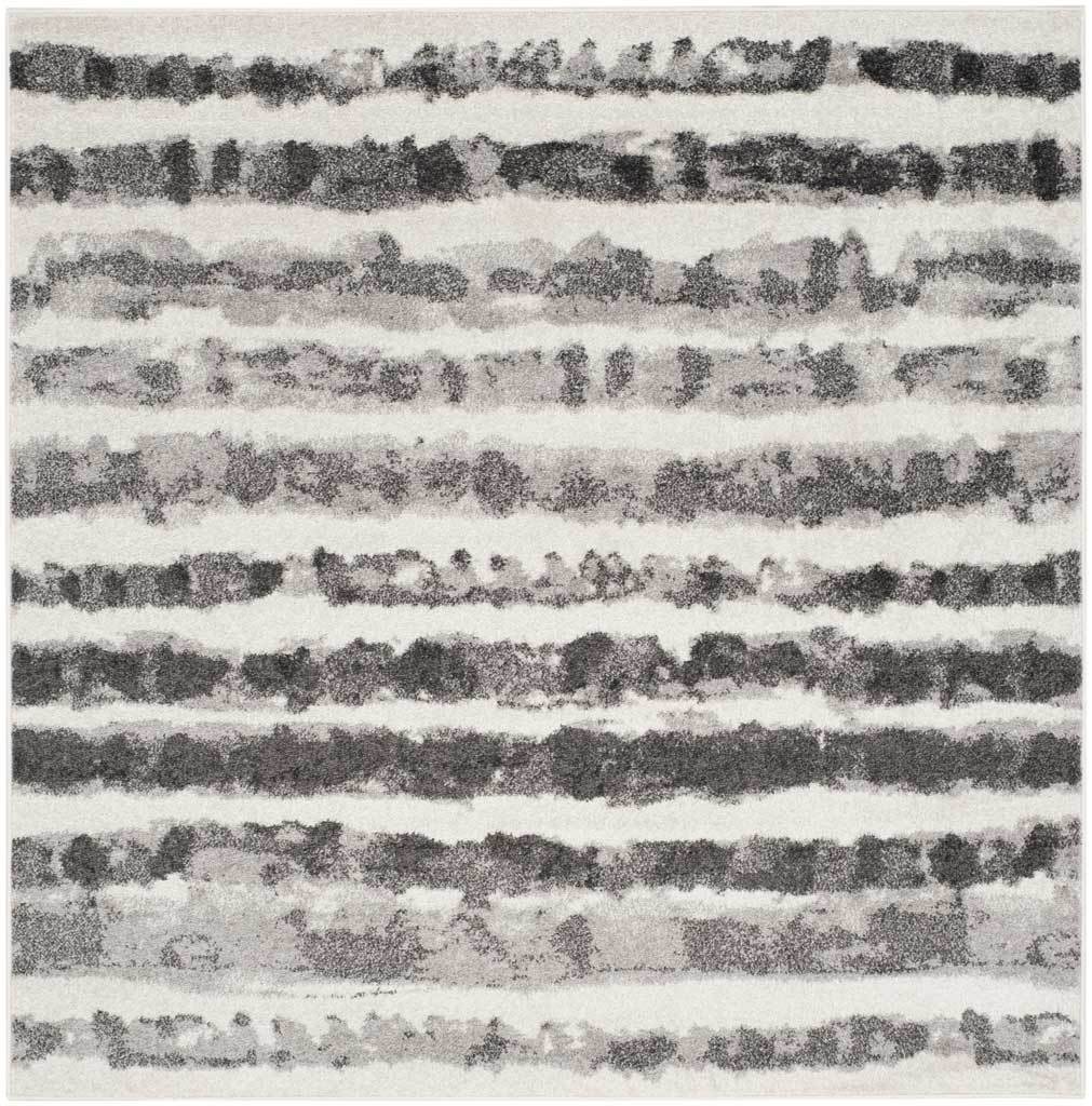 Square area rug layers charcoal brushstroke stripes across an ivory ground