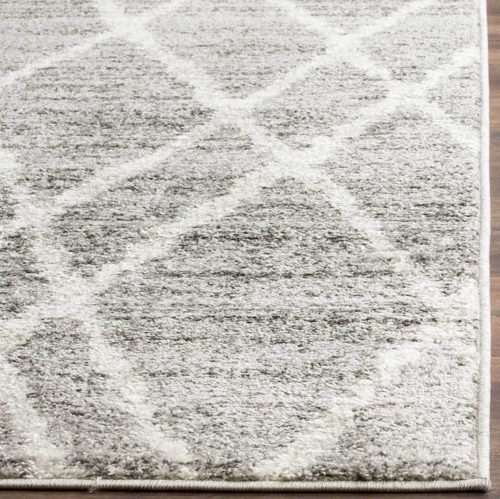 Soft, mottled gray pile, ivory lattice lines and bound edges give this rug a refined finish.